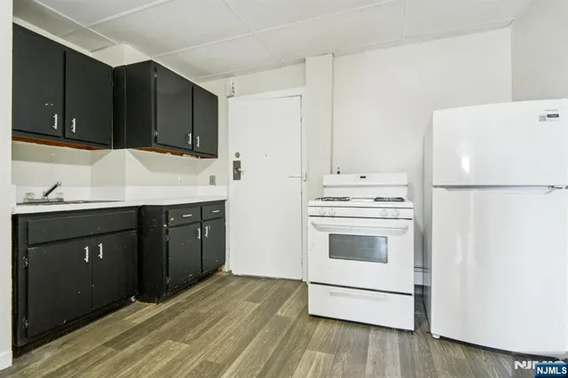 a kitchen with granite countertop a refrigerator stove and sink