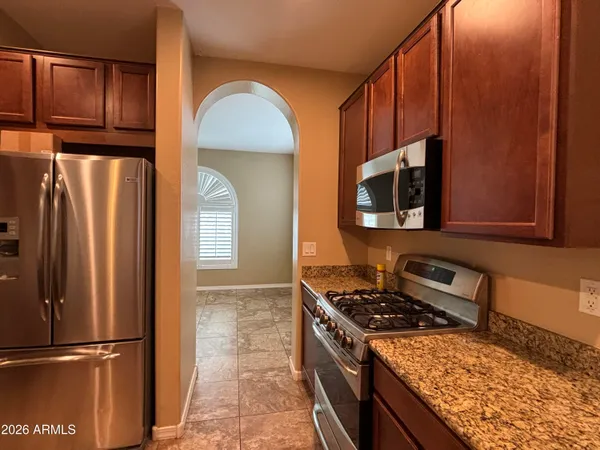 a kitchen with stainless steel appliances granite countertop a refrigerator stove and microwave