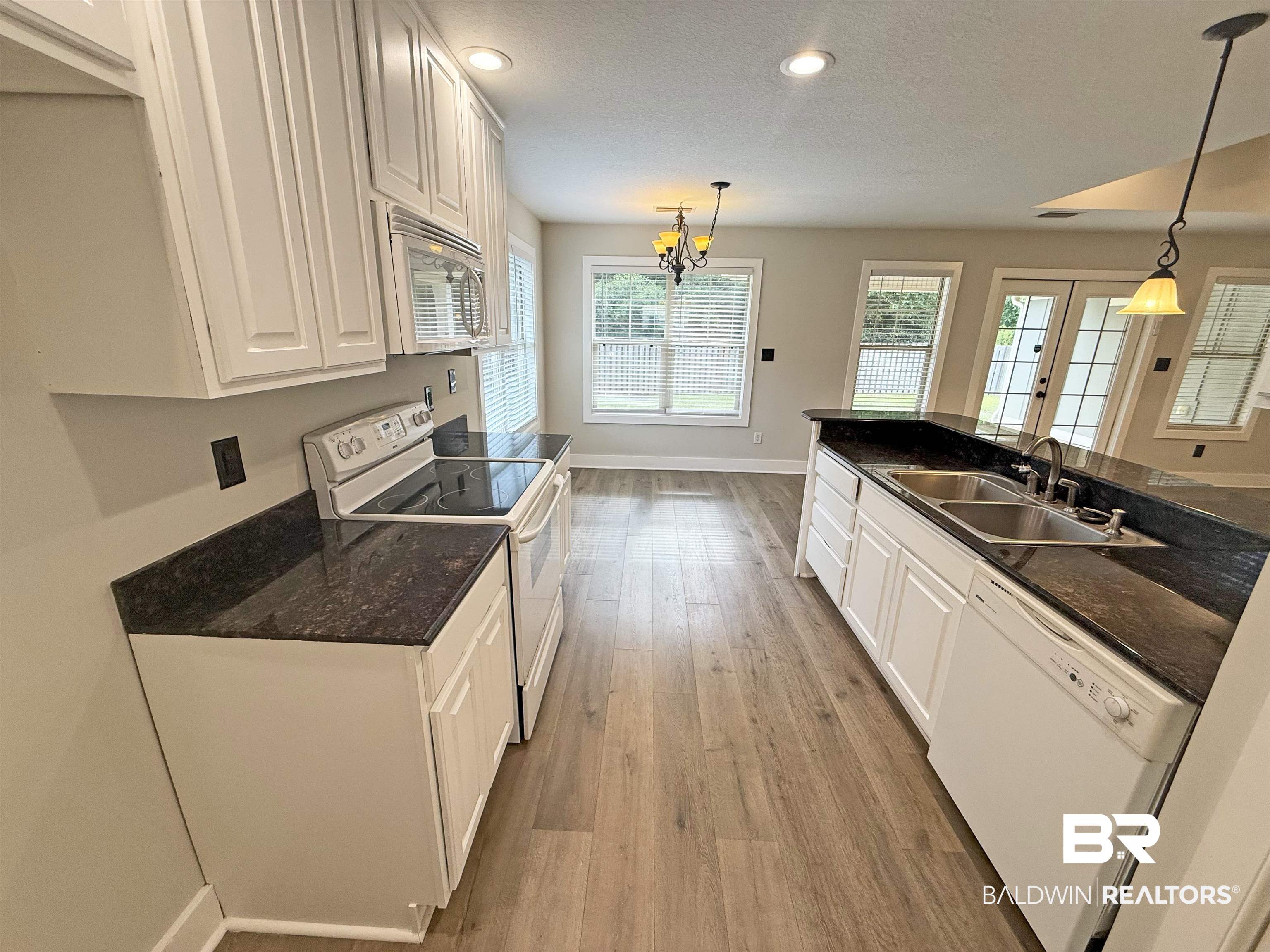 22023 Garland Loop Silverhill, AL 36576 - Photo 10 of 33 Kitchen with white appliances, white cabinets, wood finished floors, recessed lighting, and a chandelier