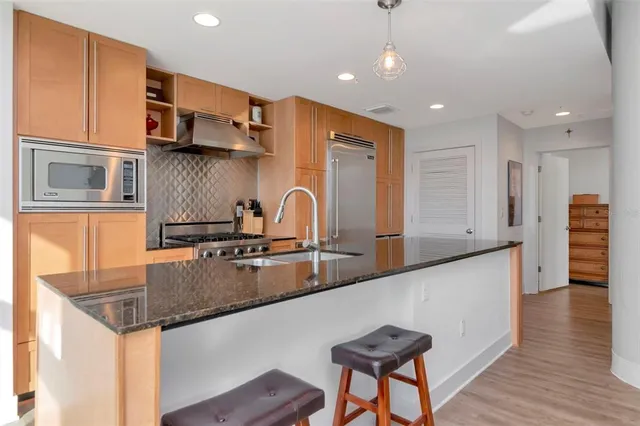 a kitchen with granite countertop a sink a counter top space and cabinets