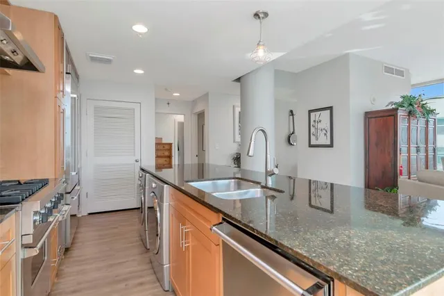 a kitchen with stainless steel appliances granite countertop a refrigerator and a sink