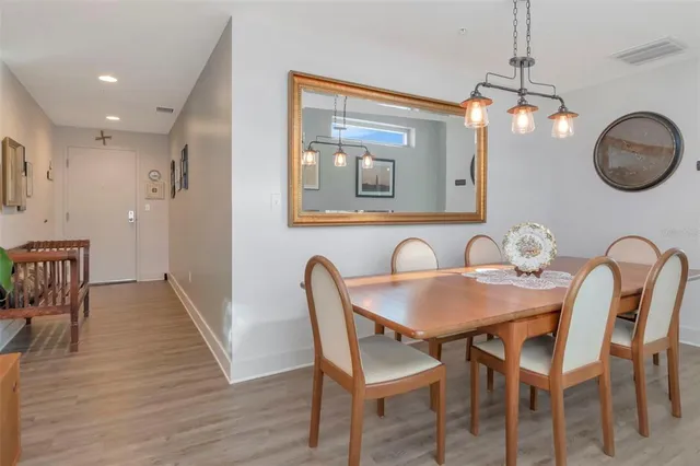 a dining room with wooden floor a glass table and chairs
