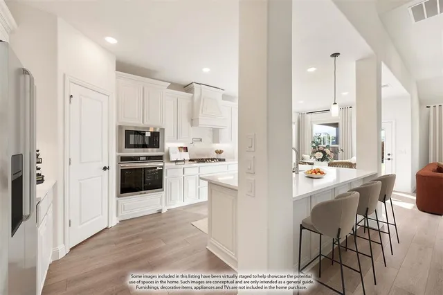 a kitchen with stainless steel appliances kitchen island granite countertop a refrigerator and a stove top oven