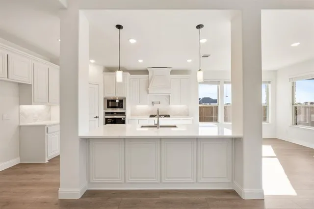 a kitchen with kitchen island white cabinets and stainless steel appliances