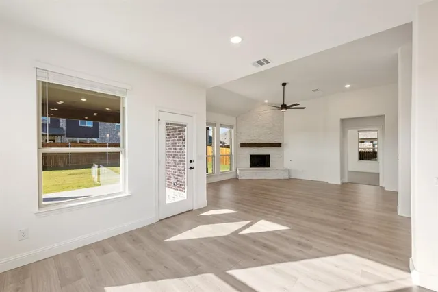 a view of a hallway with wooden floor and a living room