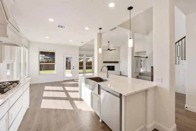 a open kitchen with stainless steel appliances granite countertop a sink stove and a refrigerator