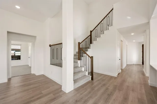 a view of a hallway with wooden floor and entryway