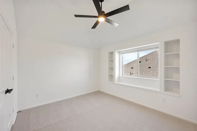 an empty room with window and fan