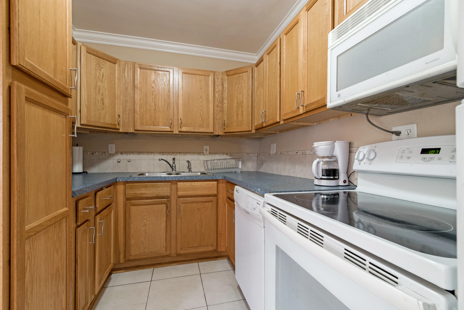 320 East Lake Road Palm Springs, FL 33461 - Photo 9 of 22 a kitchen with stainless steel appliances granite countertop a sink and cabinets