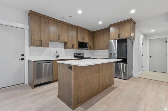 710 East Mountain Road North Ogden, UT 84414 - Photo 26 of 36 Kitchen featuring wood cabinetry with black hardware, white countertops, stainless steel appliances, and wood-finish flooring