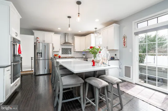 a kitchen with white cabinets and a stove with wooden floor