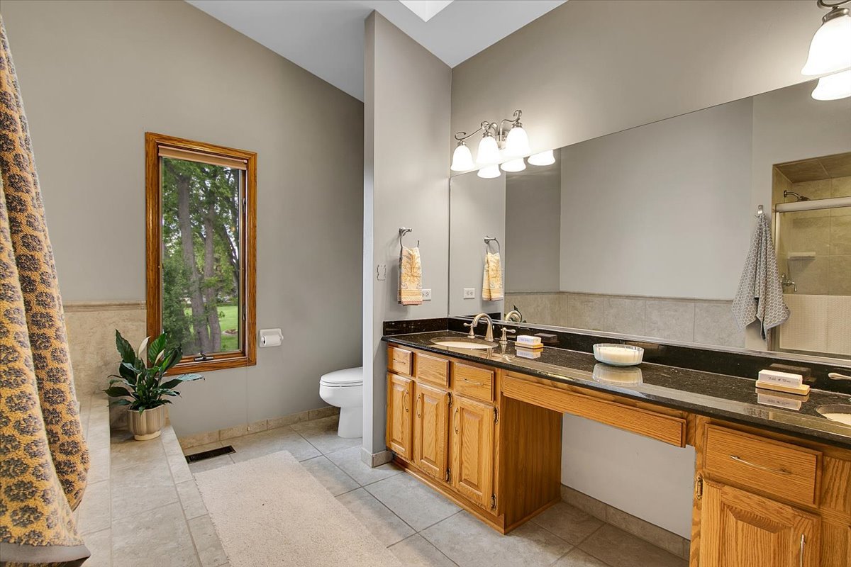 90 Briargate Road Cary, IL 60013 - Photo 17 of 42 a spacious bathroom with a granite countertop double vanity and a mirror