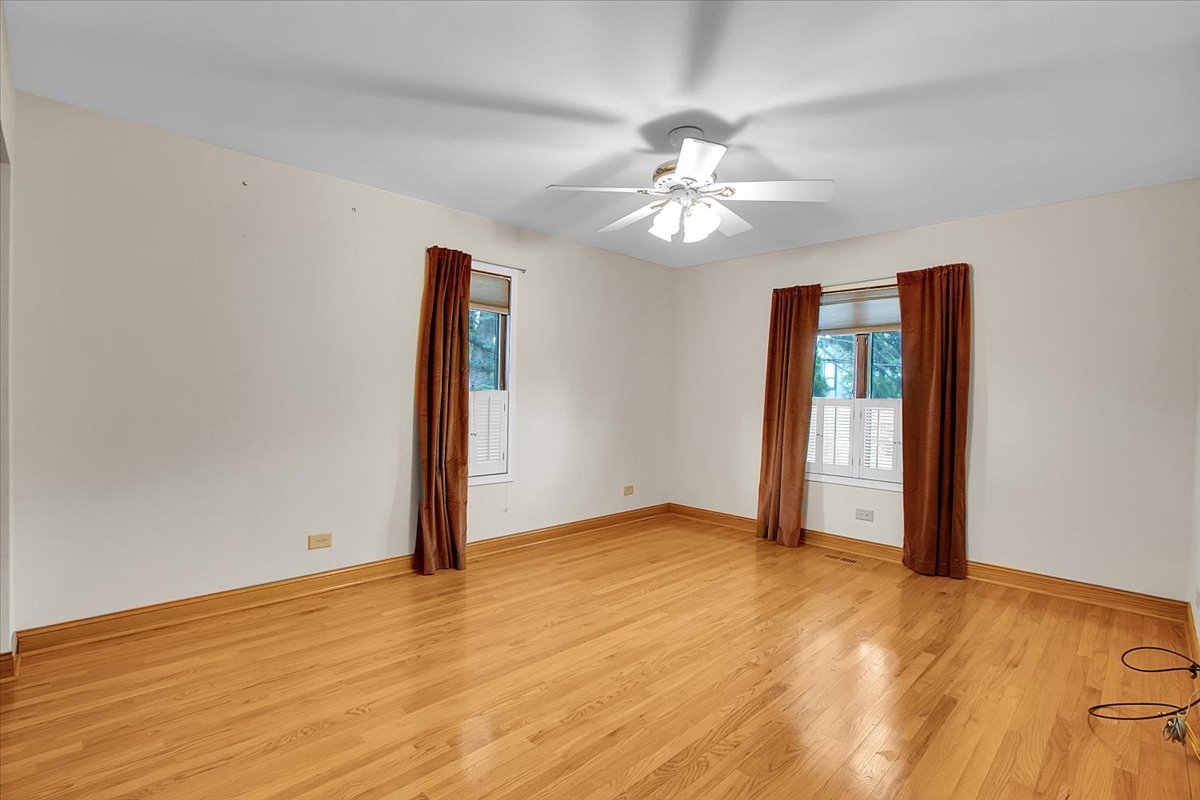 90 Briargate Road Cary, IL 60013 - Photo 18 of 42 an empty room with wooden floor chandelier fan and windows