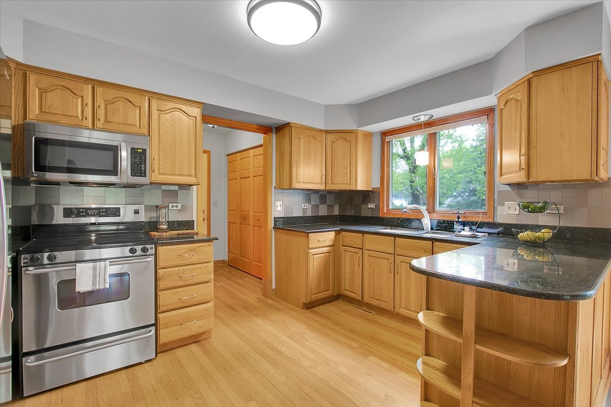 90 Briargate Road Cary, IL 60013 - Photo 6 of 42 a kitchen with stainless steel appliances granite countertop a stove a sink and a microwave