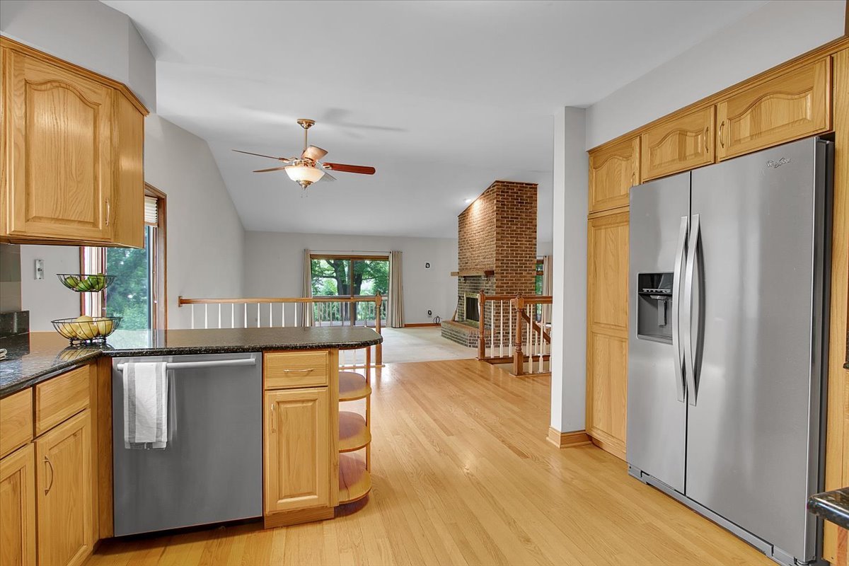 90 Briargate Road Cary, IL 60013 - Photo 7 of 42 a kitchen with stainless steel appliances granite countertop a refrigerator a stove and a wooden floors