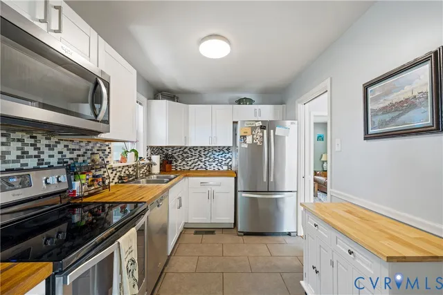 a kitchen with stainless steel appliances granite countertop a stove a refrigerator and a microwave
