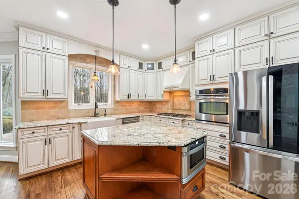 a kitchen with stainless steel appliances granite countertop a sink stove and refrigerator