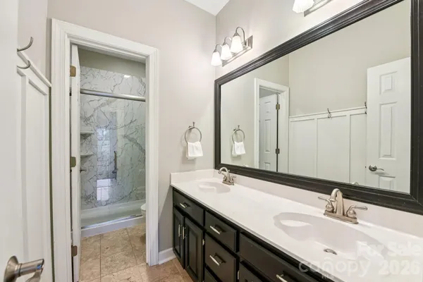 a bathroom with a double vanity sink a mirror and a shower
