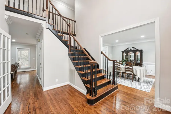 a view of a hallway with wooden floor and staircase
