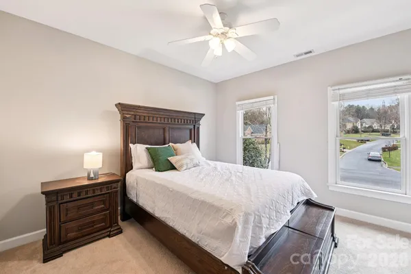 a bedroom with a bed chandelier and a window