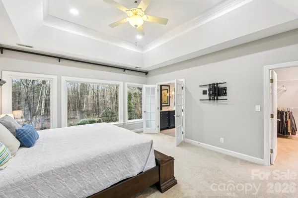a spacious bedroom with a large bed and a chandelier