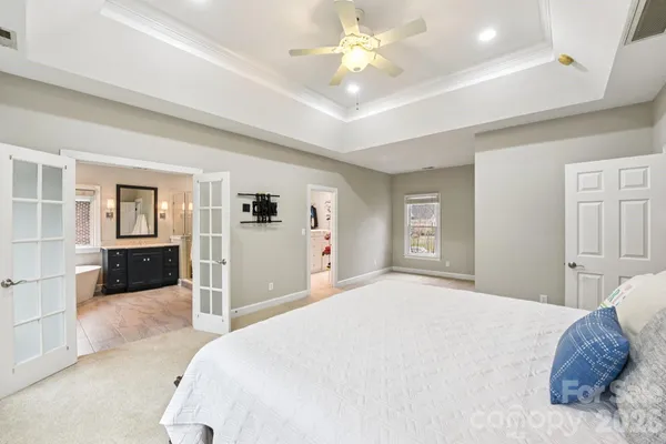 a bedroom with a large bed and a chandelier