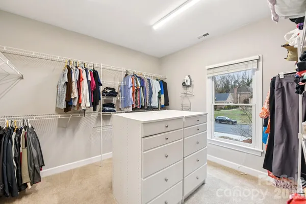 a view of walk in closet with clothes and shoes