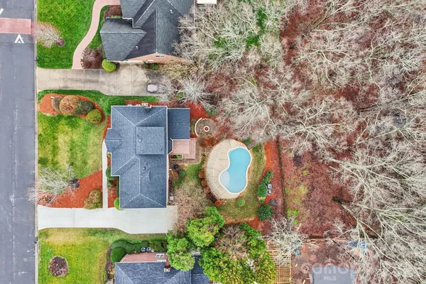 a aerial view of a house with a swimming pool a yard and a fountain