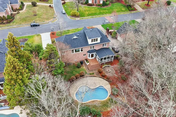 a front view of a house with a garden and trees