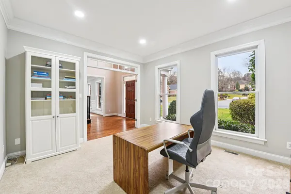 a view of a workspace with furniture and a window