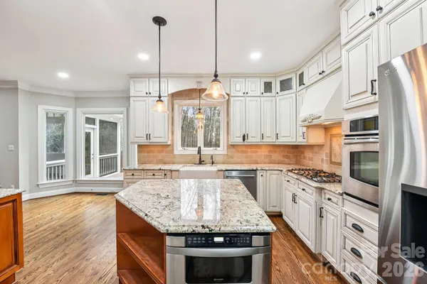a kitchen with stainless steel appliances granite countertop a stove and cabinets