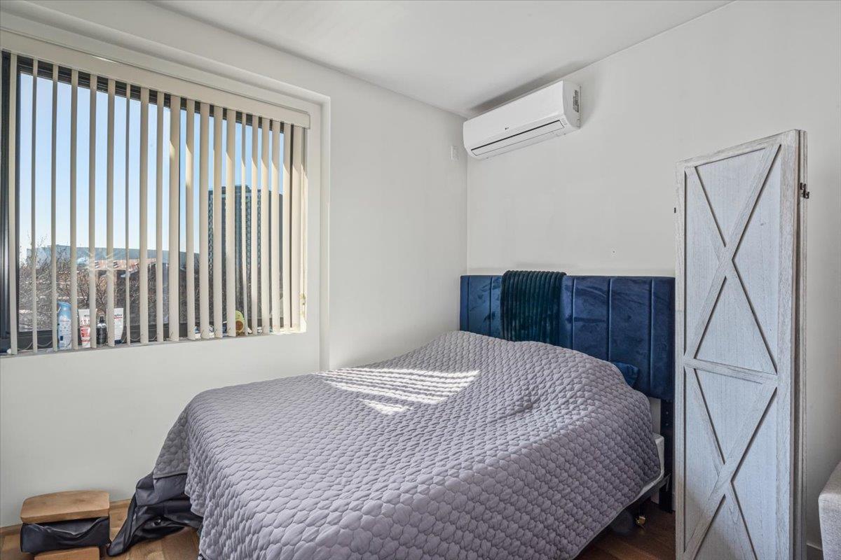 87-22 51st Avenue, Unit 4H Queens, NY 11373 - Photo 7 of 17 Bedroom with a wall unit AC and wood finished floors