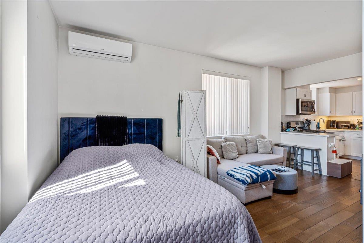 87-22 51st Avenue, Unit 4H Queens, NY 11373 - Photo 8 of 17 Bedroom featuring dark wood-type flooring and an AC wall unit