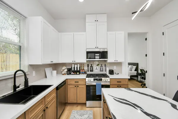 a kitchen with stainless steel appliances a sink a stove and cabinets