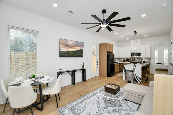 a living room with furniture kitchen view and a window