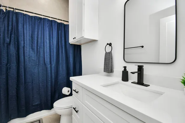 a bedroom with a bed and flat tv screen on the dresser