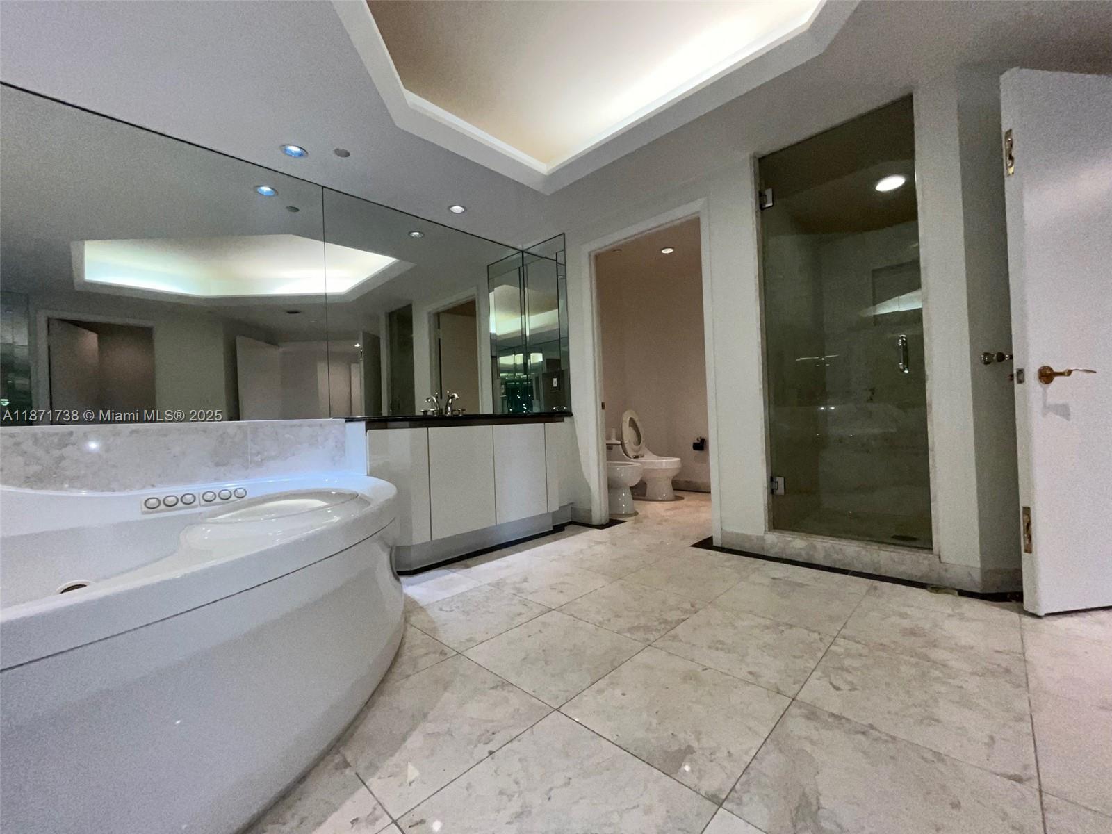 2600 East Island Boulevard, Unit 1503 Aventura, FL 33160 - Photo 13 of 36 a spacious bathroom with a tub and a mirror