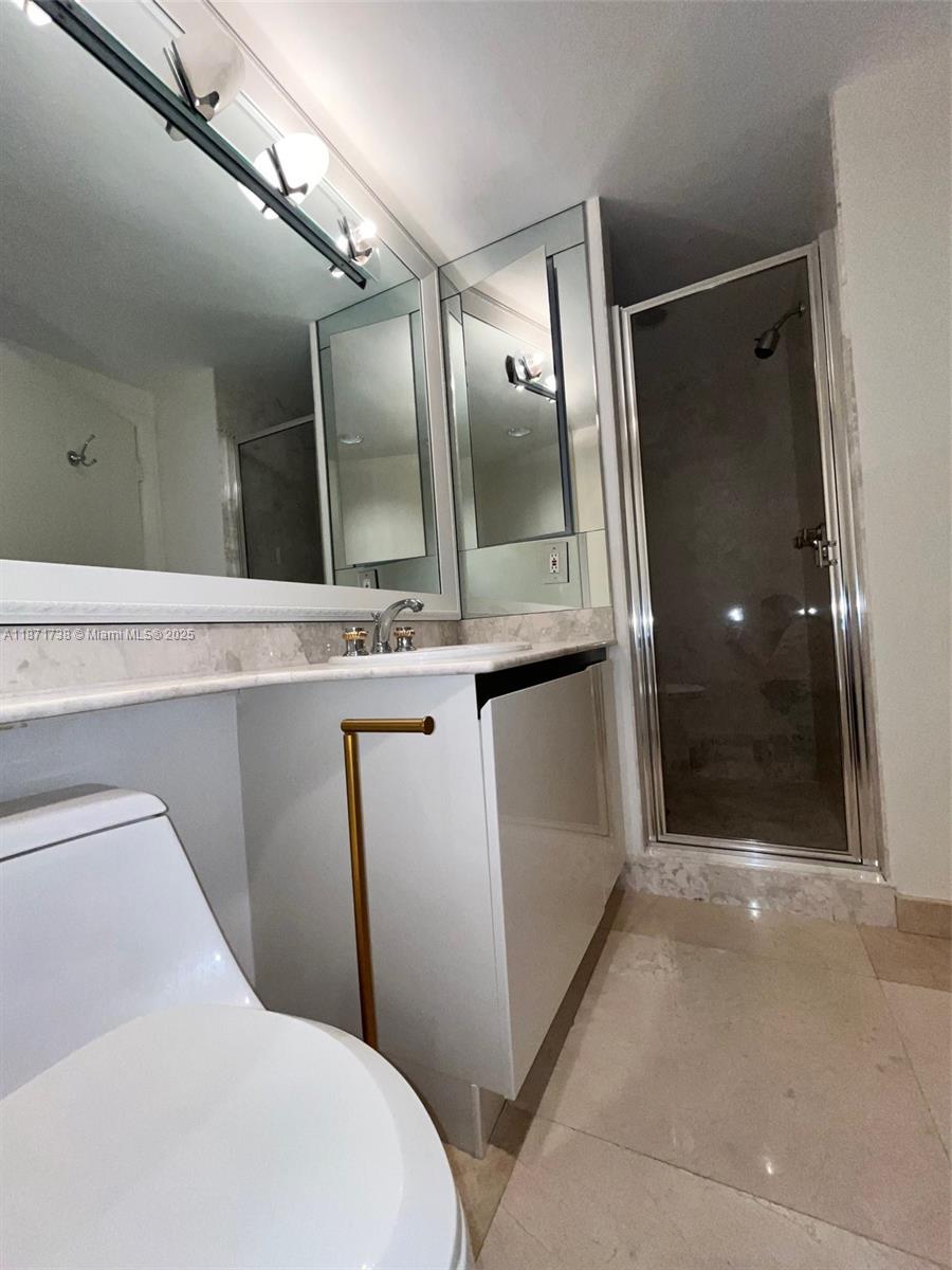 2600 East Island Boulevard, Unit 1503 Aventura, FL 33160 - Photo 21 of 36 a bathroom with a shower and a mirror
