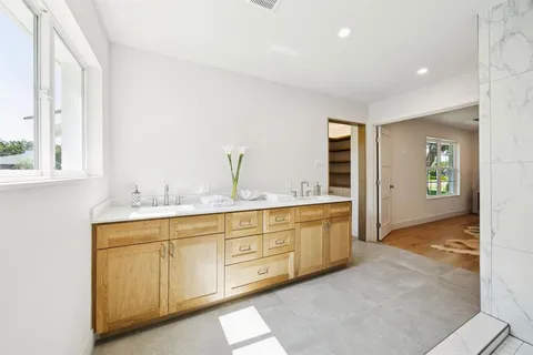 a spacious bathroom with a granite countertop sink and mirror