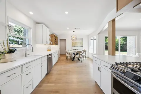 a large white kitchen with a large window