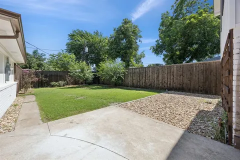 a view of backyard with wooden fence