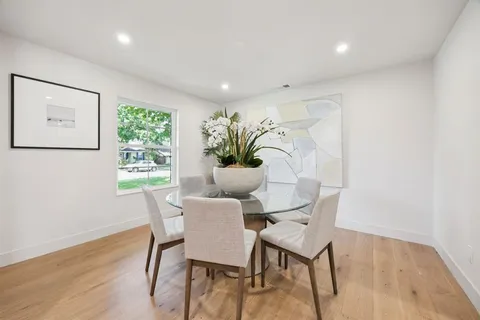 a dining room with furniture and wooden floor