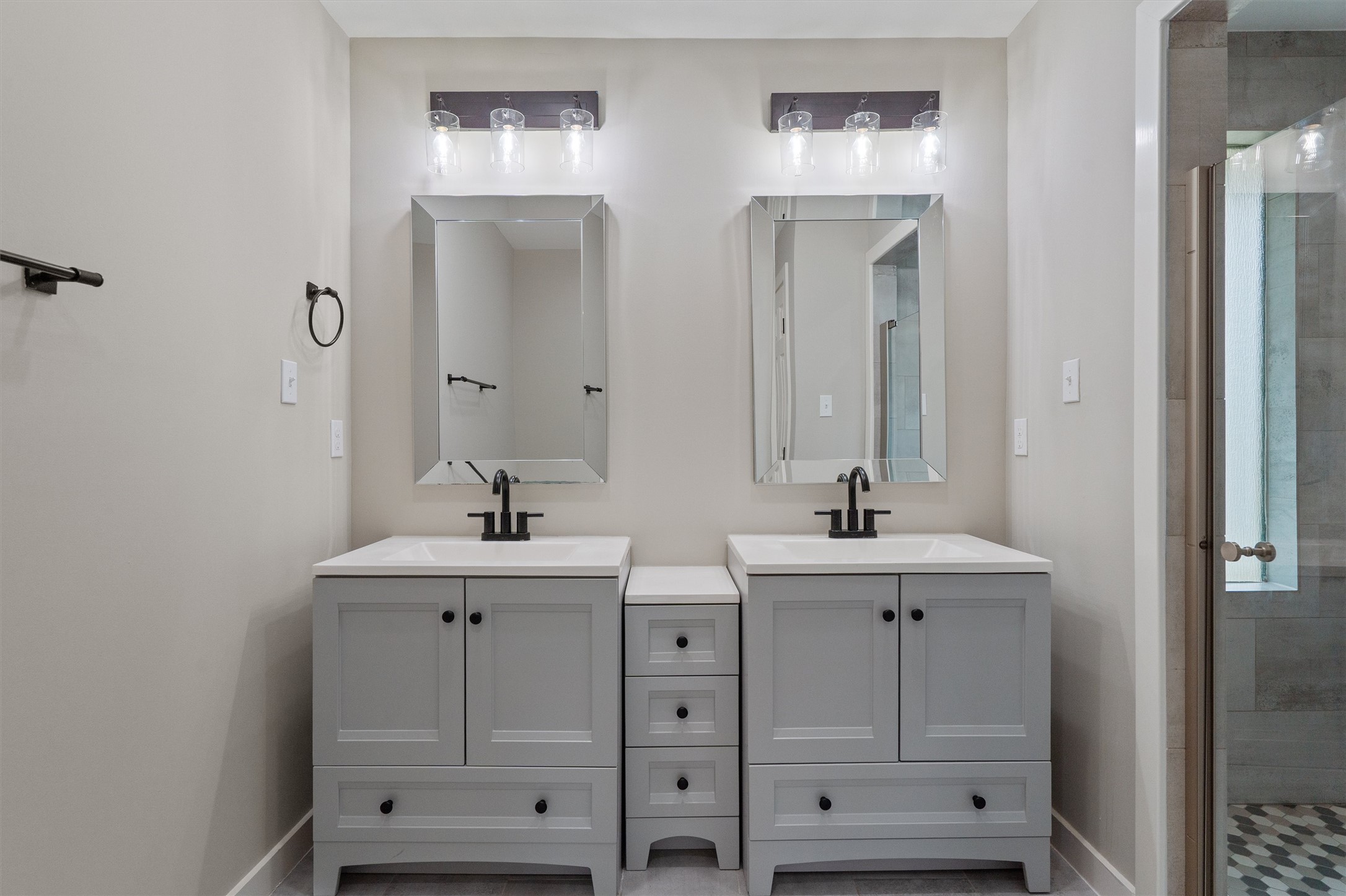 7707 Robalo Road Austin, TX 78757 - Photo 15 of 33 A well-appointed primary bathroom featuring a double vanity with ample storage and a sleek shower enclosure.