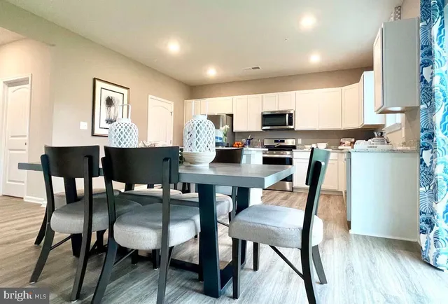 a kitchen with a dining table chairs and a refrigerator