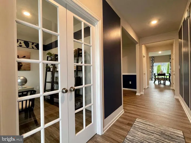 a view of a hallway with wooden floor and windows