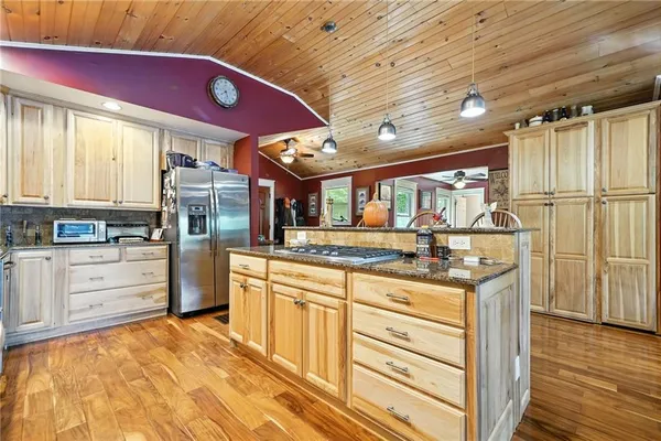 a kitchen with stainless steel appliances kitchen island granite countertop a stove a sink and a microwave