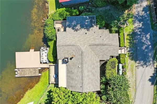 an aerial view of a house with swimming pool and large trees