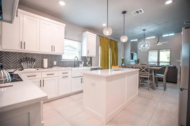 a large white kitchen with lots of counter space and a sink