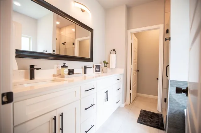 a bathroom with a double vanity sink a mirror and a