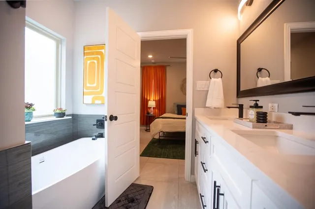 a en suite bathroom with a sink a tub and a mirror